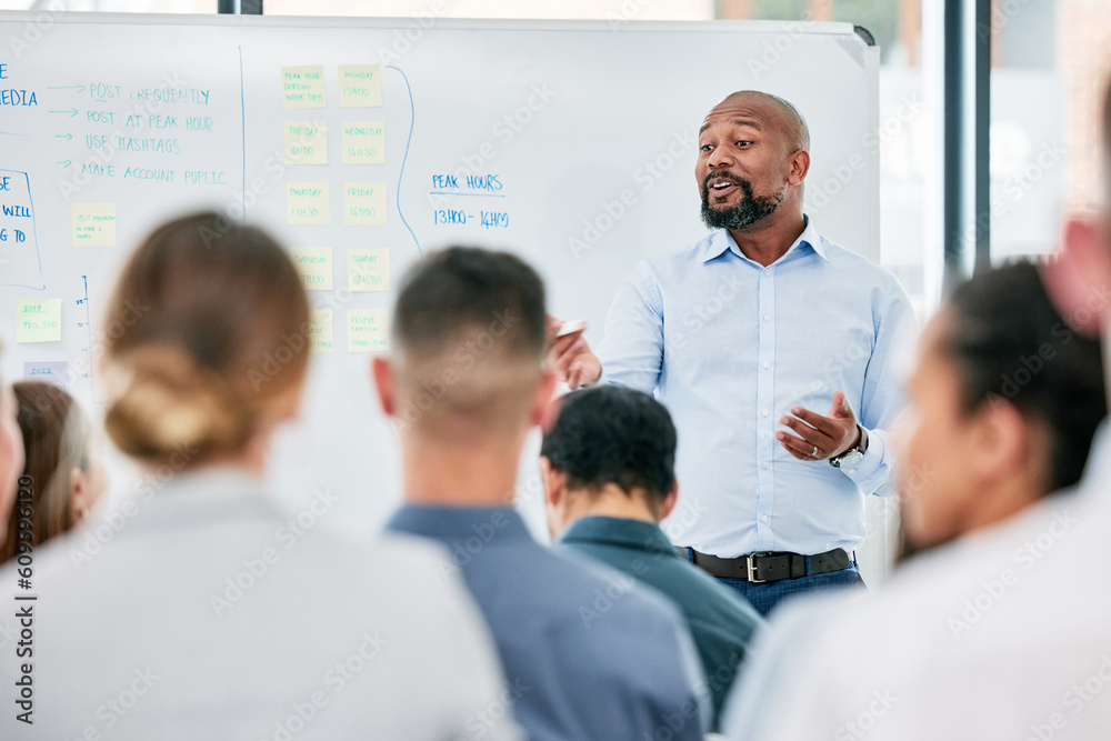 Male speaker, conference and corporate team at training for company with learning on a board with audience. Business, presentation and coach is speaking to employees during a meeting at the office.